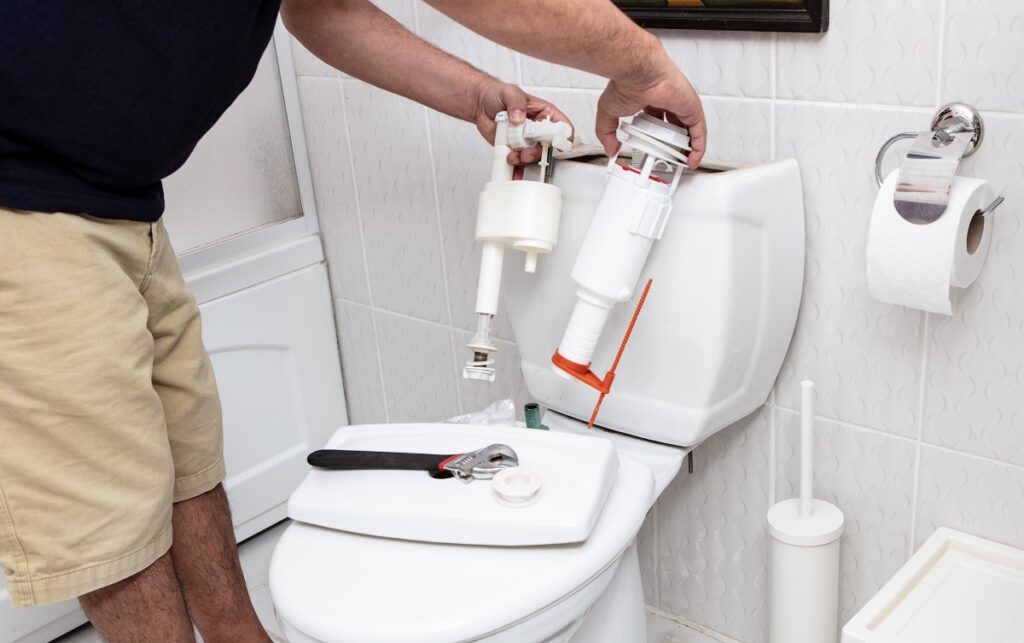 man using tools repairing reservoir